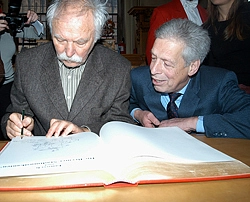 Dieses Bild zeigt Janosch, der zur Freude von Bürgermeister Henning Scherf ins Goldene Buch der Stadt malt.