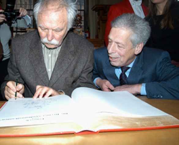 Dieses Bild zeigt Janosch, der zur Freude von Bürgermeister Henning Scherf ins Goldene Buch der Stadt malt.