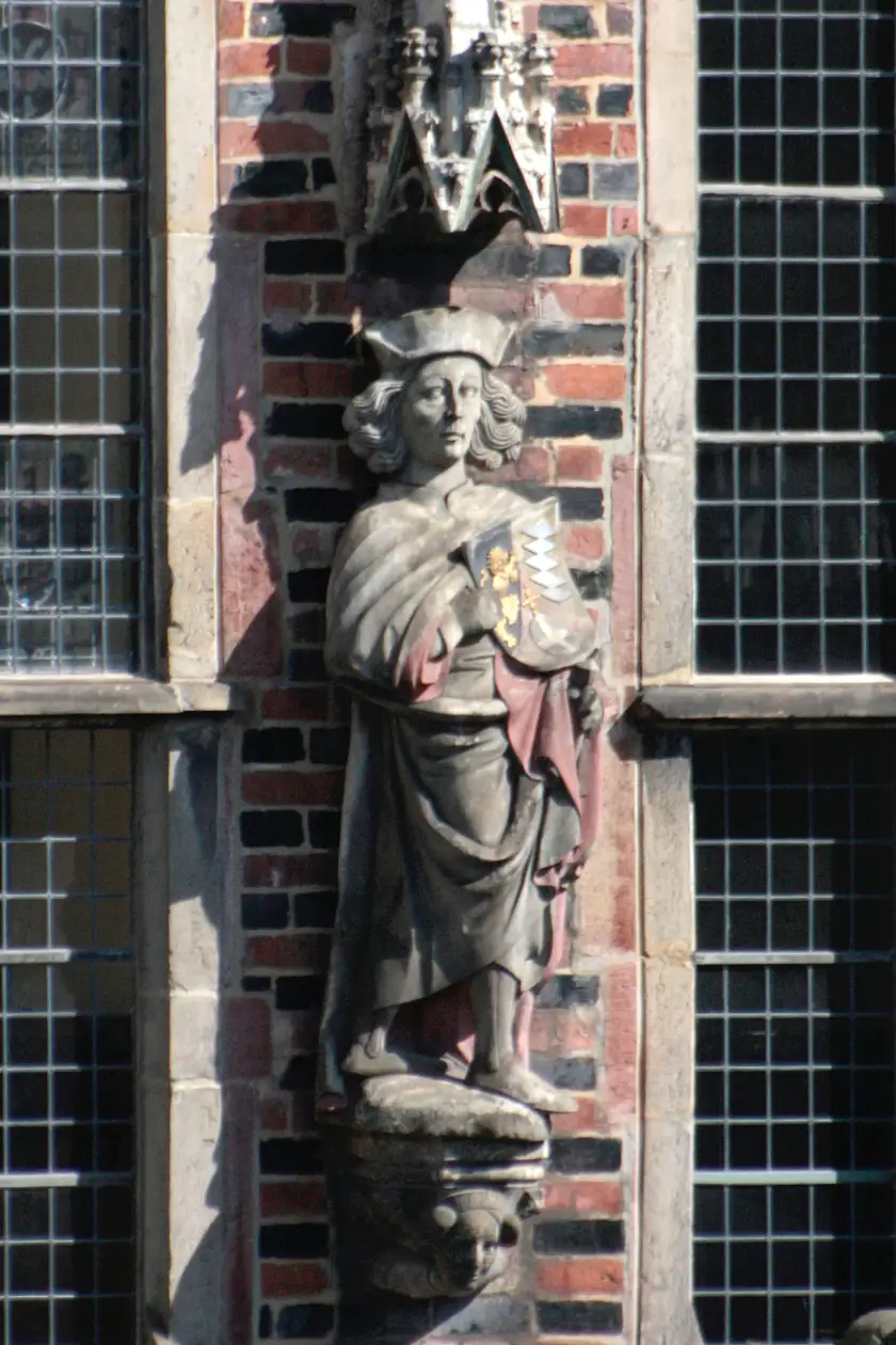 Den Kurfürst von der Pfalz schmückt ein sehr ausladender Mantel. Zu erkennen ist nur der Griff seines Schwertes in der linken Hand sowie das Wappen in der Rechten mit dem Zeichen für das Hofamt Erztruchseßamt, den Reichsapfel mit Kreuz. Der Träger dieses Amtes war für die Haupt- und Hofverwaltung sowie für die königliche Tafel zuständig. Auf dem Kopf trägt der Kurfürst eine runde Mütze mit seitlichen Klappen.