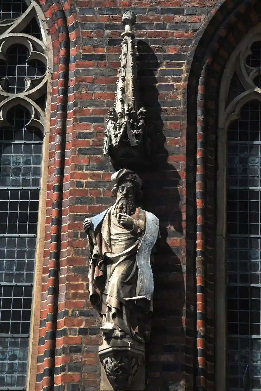 Bei der Betrachtung Hiobs fällt zuerst seine schlafmützenähnliche Kopfbedeckung ins Auge. Das über seine Schulter gezogene Spruchband hält Hiob in der rechten Hand, während er sich mit der Linken an den Bart greift.