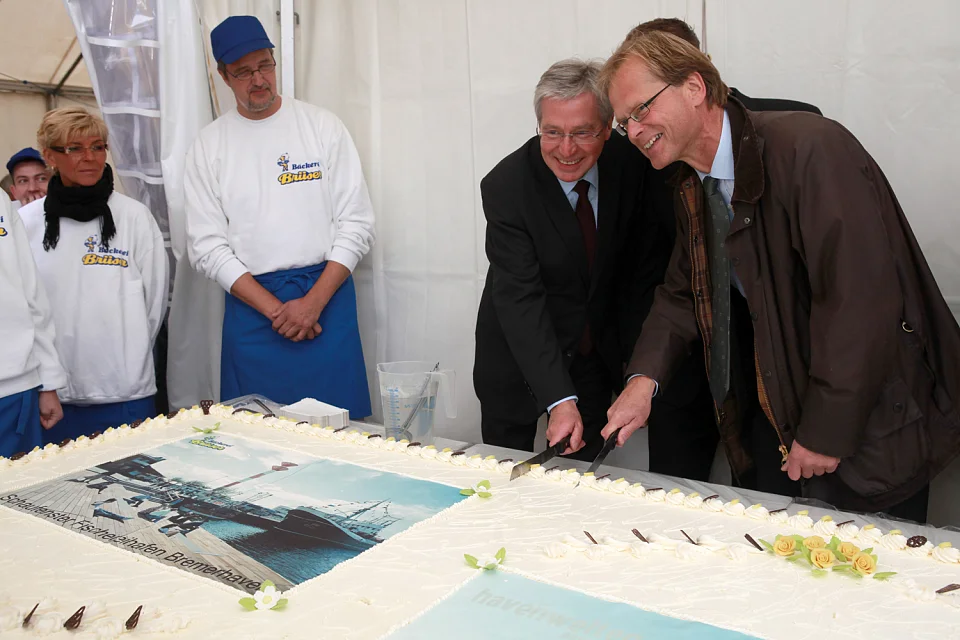 B&uuml;rgermeister Jens B&ouml;hrnsen und der Oberb&uuml;rgermeister J&ouml;rg Schulz schneiden die Bremerhaven-Torte der B&auml;ckerei Br&uuml;ser an (02.10.2010)