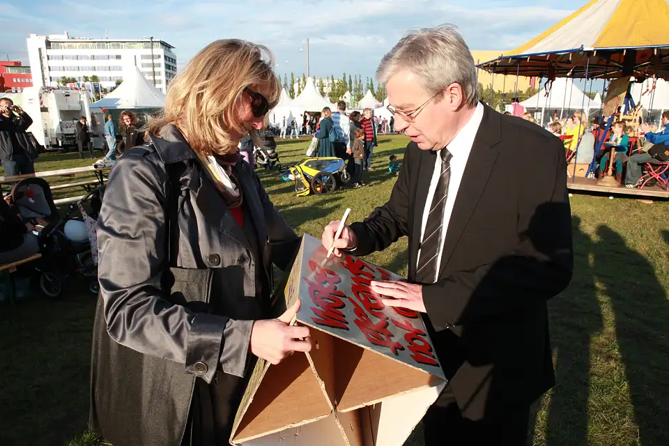 B&uuml;rgermeister Jens B&ouml;hrnsen signiert ein Erinnerungsst&uuml;ck einer Besucherin auf der L&auml;ndermeile (03.10.2010)
