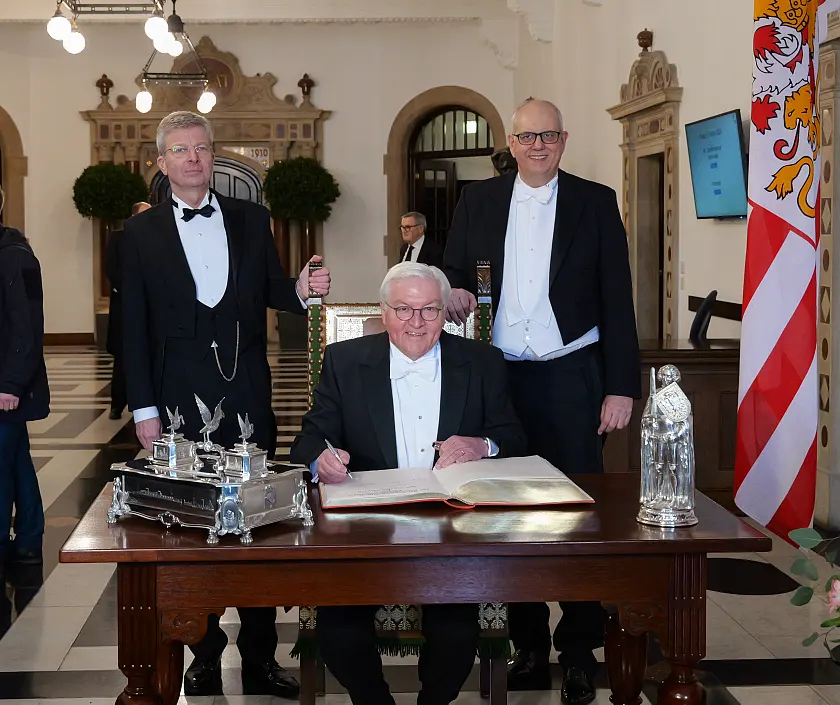 Bundespr&auml;sident Frank-Walter Steinmeier ist Ehrengast der Schaffermahlzeit. Er trug sich vor Beginn in das Goldene Buch ein, begleitet vom Verwaltenden Vorsteher des Haus Seefahrt Henry Lamotte (links) und B&uuml;rgermeister Andreas Bovenschulte.