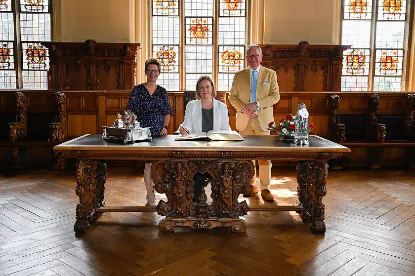 Die estnische Botschafterin Marika Linntam (Mitte) trägt sich in das Goldene Buch ein. Empfangen wurden sie und Honorarkonsul Dr. Til Assmann von Sozialsenatorin Dr. Claudia Schilling.