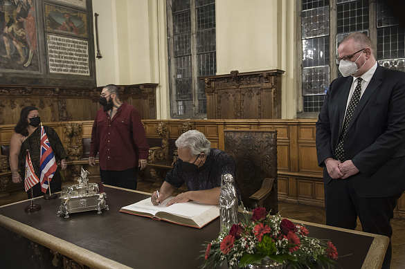 Edward Halealoha Ayau, Repräsentant (Hui Iwi Kuamo’o) des indigenen hawaiischen Volkes, trägt sich in der Oberen Rathaushalle ins Goldene Buch ein. Dabei schaut ihm Staatsrat Dr. Olaf Joachim zu. © Volker Beinhorn 