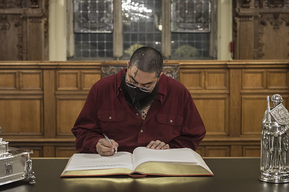 Mana Caceres, Repräsentant (Hui Iwi Kuamo’o) des indigenen hawaiischen Volkes, trägt sich in der Oberen Rathaushalle ins Goldene Buch ein. © Volker Beinhorn