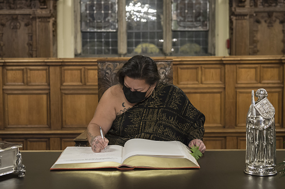 Kalehua Caceres, Repräsentantin (Hui Iwi Kuamo’o) des indigenen hawaiischen Volkes, trägt sich in der Oberen Rathaushalle ins Goldene Buch ein. © Volker Beinhorn