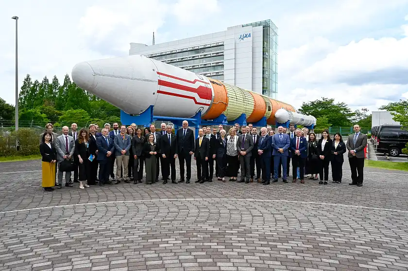 Gruppenfoto vor einer japanischen Raumfahrtrakete
