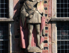 Der Kurfürst von Trier ist über einem sehr kurzen Gewand in einen weiten Mantel gehüllt. Auffällig ist die große Kette; in den Händen hält er seine Waffen: Schwert und Dolch. Auf seinem linken Arm prangt ein Schild, das ursprünglich ein rotes Kreuz mit weißem Hintergrund zeigte