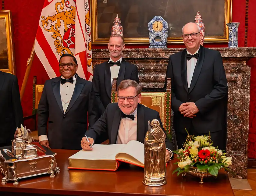 Bundesaußenminister Johann Wadephul (sitzend) und sein Amtskollege aus Sri Lanka, Vijitha Herath, (links) trugen sich vor dem Fest in das Goldene Buche Bremens ein. Mit dabei: Bürgermeister Andreas Bovenschulte (rechts) und der Vorsitzende des Ostasiatischen Vereins, Thomas Kriwat.