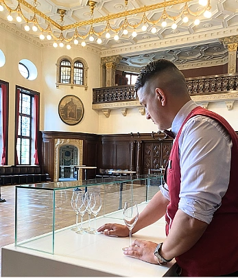 Ein Auszubildender richtet Gläser an 