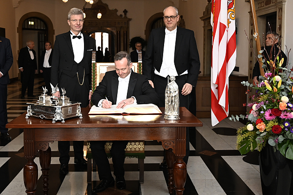 Bundesminister Volker Wissing trägt sich anlässlich der 479. Schaffermahlzeit in das Goldene Buch ein; mit im Bild: Bürgermeister Andreas Bovenschulte und der Verwaltende Vorsteher von Haus Seefahrt, Henry Lamotte (von rechts).