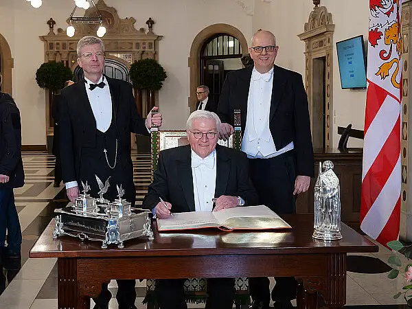 Bundespräsident Frank-Walter Steinmeier ist Ehrengast der Schaffermahlzeit. Er trug sich vor Beginn in das Goldene Buch ein, begleitet vom Verwaltenden Vorsteher des Haus Seefahrt Henry Lamotte (links) und Bürgermeister Andreas Bovenschulte.