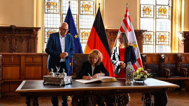Bundesbildungsministerin Karin Prien (Mitte) trägt sich im Beisein von Bürgermeister Andreas Bovenschulte und der Senatorin für Kinder und Bildung, Sascha Karolin Aulepp in das Goldene Buch ein.