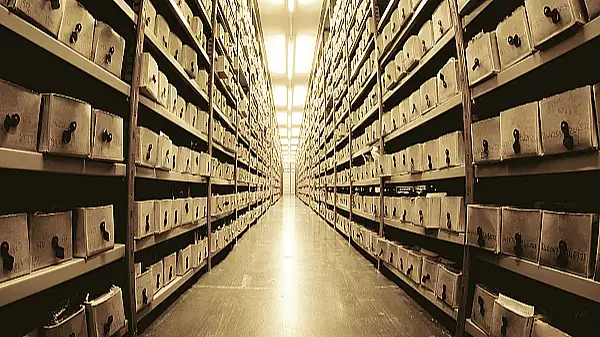 Blick in einem Gang wo links und rechts Regale stehen und in diesen viele Dokumente archiviert sind.